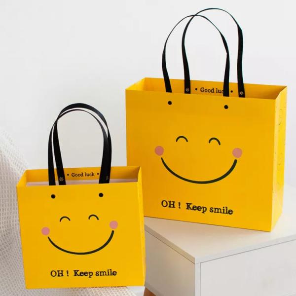 Buy cheap ISO Shock Resistant Smile Face Kraft Paper Bags Yellow Square Bottom Paper Bag from wholesalers
