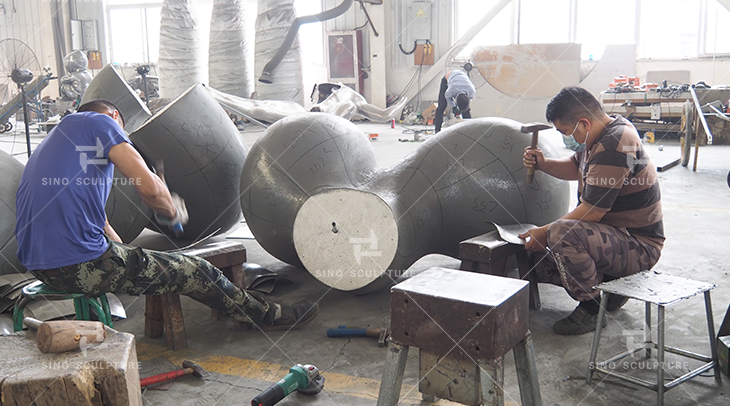 Hand-forging the stainless steel panels on the hard foam model