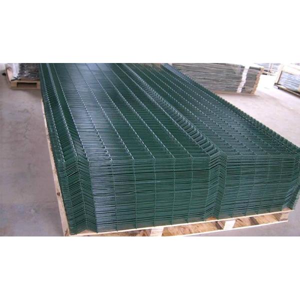 Green 3D fence panels are packed on the top of each other in a wooden pallet.