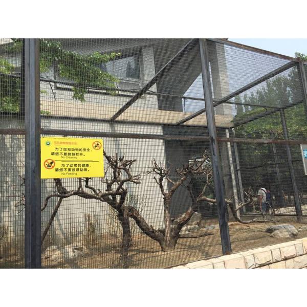 A rectangular hole aviary mesh with metal frame is used as aviary house. In the aviary house, there are many withered trees.