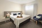 Fabric upholstery King size bed and laminate wood desk tables with luggage